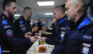 policjanci z kontyngentu w Kosowie podczas spotkania świątecznego  łamią się opłatkiem