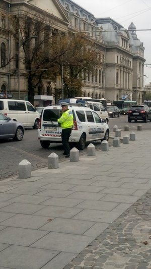 Radiowóz i policjant ruchu drogowego na jednej z ulic w Bukareszcie