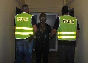 Policjanci prowadzą zatrzymanego