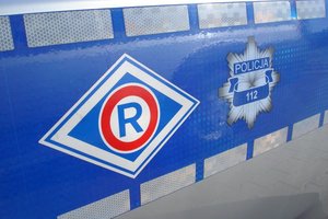Logo ruchu drogowego i gwiazda policyjna na radiowozie.