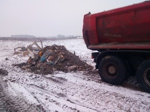 Auto ciężarowe, obok odpady.