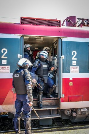 Policjanci podczas zabezpieczania pociągu w którym znajdują się kibice.