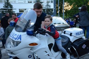 Kilkuletni chłopiec siedzi na policyjnym motocyklu.