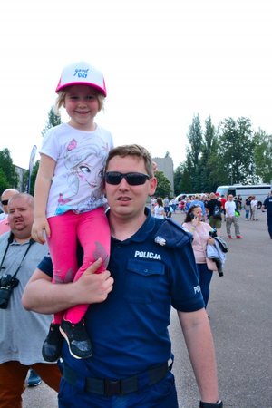 Policjant niesie na ramieniu dziewczynkę.