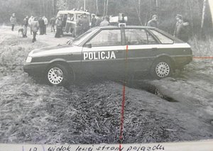 archiwalne czarno-białe zdjęcie na którym widac wyciągniętego z wody poloneza -radiowóz i osoby pracujące na miejscu ujawnienia auta i zwłok policjanta.