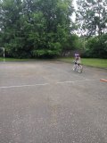 Rowerzystka na boisku szkolnym.