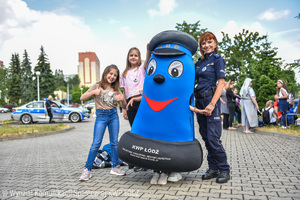 Na zdjęciu widać policjantkę w granatowym mundurze, strój Komisarza Błyska oraz dwie dziewczynki, które uczestniczyły w pikniku.