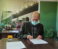 Dyrektor piotrkowskiego szpitala składa podpis na dokumencie przekazania zabezpieczonego przez policjantów alkoholu