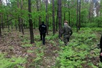 policjant z żołnierzem WOT szukający w lesie psa