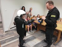 policjant prezentuje dzieciom policyjny sprzęt