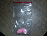 na zdjęciu widzimy narkotyki w postaci różowych tabletek zapakowane w foliowy woreczek