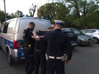 Policjanci prowadzą zatrzymanego do radiowozu