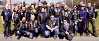 Grupa motocyklistów stojąca przodem do obiektywu. Mężczyźni i kobiety ubrani są w ubiór klubów motocyklowych. Wraz z nimi stoi policjantka Wydziału Ruchy Drogowego KMP w Łodzi.
