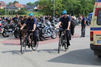policjanci jadący na rowerach wśród motocykli obok karetki pogotowia ratunkowego