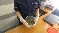 policjantka trzyma w rękach miskę z zabezpieczonym suszem marihuany