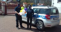 policjanci dostarczają tort urodzinowy dla dziewczynki przebywającej na kwarantannie