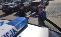 policjant rozdaje mieszkańcom maseczki