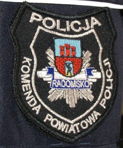plakietka z munduru z napisem Komenda Powiatowa Policji w Radomsku i herbem miasta