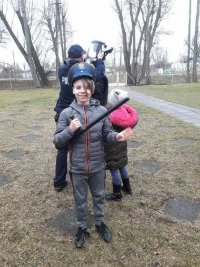 Chłopiec w czapce policjanta, trzymający w ręce pałkę typu tonfa