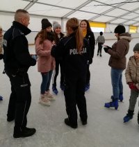 policjanci na lodowisku rozdają ulotki