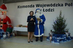Policjantka - naczelnik Wydziału kadr KWP w Łodzi stoi obok Niebieskiego Mikołaja