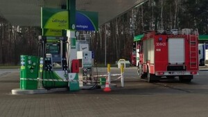 Uszkodzony dystrybutor, obok auto Straży Pożarnej.