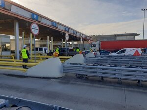 Policjanci stoją przy bramkach na autostradzie i sprawdzają trzeźwość.