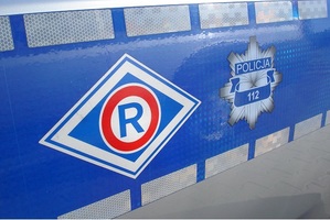 Logo ruchu drogowego na tle radiowozu, obok gwiazda policyjna z apisem Policja 112.