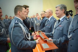 Komendant wręcza pamiątkową szablę oficerowi odchodzącemu na emeryturę.