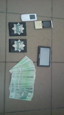 zabezpieczone przedmioty takie jak podrobione  odznaki policyjne, odzyskana gotówka i telefony