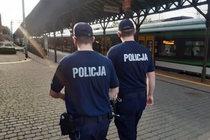 Umundurowani policjanci patrolują teren dworca kolejowego.