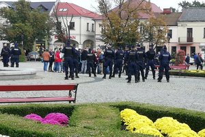 Łowicz, protest koronasceptyków, umundurowani policjanci zabezpieczają zgromadzenie.