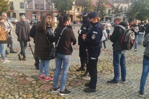 Łowicz, protest koronasceptyków, umundurowani policjanci zabezpieczają zgromadzenie.