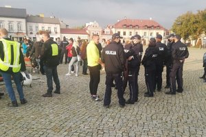 Łowicz, protest koronasceptyków, umundurowani policjanci zabezpieczają zgromadzenie.