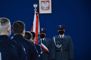 Ślubujący policjanci, w tle sztandar.