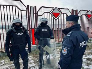 Zastępca komendanta wojewódzkiego w Łodzi rozmawia z dwoma policjantami z oddziału prewencji.