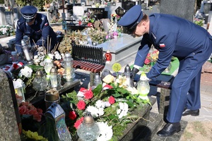 Cmentarz przy ul. Ogrodowej, dwaj policjanci ustawiają znicze na grobach poległych policjantów.