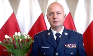 Komendant Główny Policji na tle polskich flag