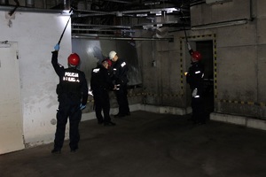 Policjanci sprawdzają pomieszczenia w budynku.