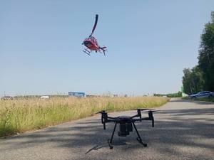 dron na ziemi a w powietrzu śmigłowiec policyjny