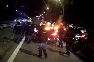 Widać w nocy na trasie stojące auta, radiowóz i policjantów z OPP.