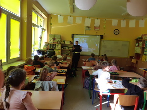 policjantka w klasie mówi uczniom o bezpieczeństwie na drodze i elementach odblaskowych