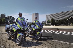 dwa motocykle policyjne i obok funkcjonariusze