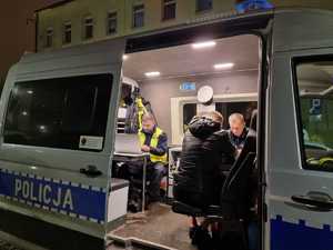 Policjanci z osobą kontrolowaną w radiowozie