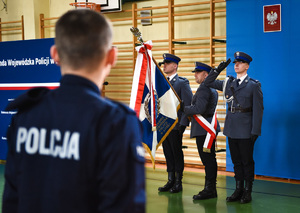 Policjanci trzymający sztandar.