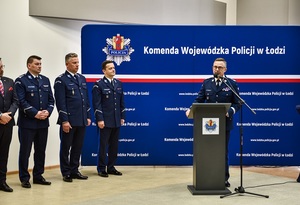 Komendant Wojewódzki Policji w Łodzi stoi przy mównicy, obok kadra garnizonu łódzkiego.