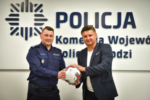 Inspektor Tomasz Olczyk i były piłkarz Marek Citko trzymają w rękach piłkę.