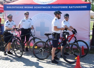 Policjanci stoją przy swoich rowerach.