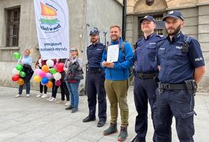 Damian z towarzyszami i policjantami spacerując ulicą Piotrkowską.