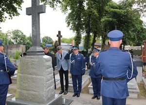 Policjanci oddają hołd przed grobem.
